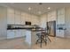 Spacious kitchen with white cabinets, granite counters, stainless appliances, and a breakfast bar with seating at 8944 Skye Canyon Ranch St, Las Vegas, NV 89166