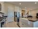 Open kitchen featuring an island with a farmhouse sink, stainless steel appliances, and white cabinetry at 8944 Skye Canyon Ranch St, Las Vegas, NV 89166