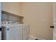Bright laundry room featuring a white washer and dryer with a shelf for storage at 8944 Skye Canyon Ranch St, Las Vegas, NV 89166