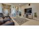 Comfortable living room area with tile floors and a large television for entertainment at 8944 Skye Canyon Ranch St, Las Vegas, NV 89166