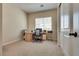 Carpeted office space with neutral walls, with a large desk and a large window at 8944 Skye Canyon Ranch St, Las Vegas, NV 89166
