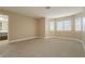 Spacious main bedroom with neutral carpet and walls, windows, and a view into ensuite bathroom at 9004 Crystal Glass Dr, Las Vegas, NV 89117