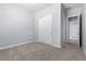 Carpeted bedroom with closet and door to hall with modern neutral design at 10158 Super Jovian St, Las Vegas, NV 89143
