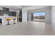 Open-concept living space with tile flooring, modern kitchen, and sliding glass doors to the backyard at 10158 Super Jovian St, Las Vegas, NV 89143