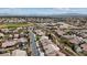 Expansive aerial view of a suburban neighborhood featuring single-Gathering homes, green spaces, and mountain views in the distance at 10563 Sunblower Ave, Las Vegas, NV 89135