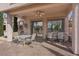 Covered outdoor patio with a table and chairs, overlooking the backyard at 10563 Sunblower Ave, Las Vegas, NV 89135