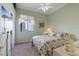 Bright bedroom features neutral carpet, decorative floral bedding, ceiling fan, and window at 10563 Sunblower Ave, Las Vegas, NV 89135