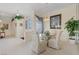 Elegant dining room featuring a glass table, upholstered chairs, and neutral decor near front entry at 10563 Sunblower Ave, Las Vegas, NV 89135