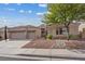Charming single-story home featuring a well-manicured front yard with desert landscaping and a three-car garage at 10563 Sunblower Ave, Las Vegas, NV 89135