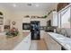 Well-lit kitchen with white cabinetry, tile floors, granite countertops, and modern black appliances at 10563 Sunblower Ave, Las Vegas, NV 89135
