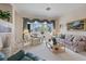 Comfortable living room with large windows, a cozy seating arrangement, and carpeted floors at 10563 Sunblower Ave, Las Vegas, NV 89135