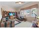 Comfortable living room featuring plaid furniture, built-in shelving, and large windows at 10563 Sunblower Ave, Las Vegas, NV 89135