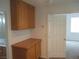 Hallway with wood cabinets that leads into a bathroom on the left and a bedroom on the right at 11039 Pegasus Dr, Las Vegas, NV 89135