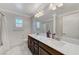 Bathroom featuring double sink vanity, large mirror, and wood look tile floors at 134 Lomita Heights Dr, Las Vegas, NV 89138