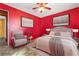 Cozy bedroom featuring bright red walls, neutral furniture, and a ceiling fan for added comfort at 1805 Helen Ave, North Las Vegas, NV 89032