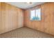 This bedroom is bright and spacious with natural light with wood paneled walls and neutral color carpeting at 1805 Helen Ave, North Las Vegas, NV 89032