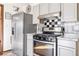 Renovated kitchen with stainless steel appliances and mosaic backsplash at 1805 Helen Ave, North Las Vegas, NV 89032