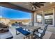 Outdoor kitchen with a grill, dining table, pool, and hillside views at 1968 Regal Bluff Dr, Henderson, NV 89052