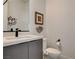 Modern powder room features floating vanity, designer mirror, and unique artwork at 1968 Regal Bluff Dr, Henderson, NV 89052