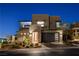 Modern two-story home featuring stone accents, an attached garage, and manicured landscaping at 1968 Regal Bluff Dr, Henderson, NV 89052
