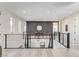 Bright hallway with modern railings and a view of the landing's accent wall with round mirror at 1968 Regal Bluff Dr, Henderson, NV 89052
