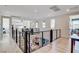Open hallway with sleek railings and a view into the downstairs living room and upstairs den at 1968 Regal Bluff Dr, Henderson, NV 89052