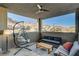 This covered patio has a hanging chair, comfortable sofa, and mountain views at 1968 Regal Bluff Dr, Henderson, NV 89052