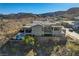 A tan two-story home features an in-ground pool, patio, and mountain views at 1968 Regal Bluff Dr, Henderson, NV 89052