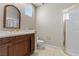 Bathroom showcasing a white tile shower, stained vanity, sink and large mirror at 2101 Strada Mia Ct, Las Vegas, NV 89117