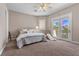 Bright bedroom featuring a queen bed, ceiling fan, and french doors to the balcony at 2101 Strada Mia Ct, Las Vegas, NV 89117