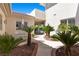 Courtyard with pavers, lush palms and outdoor seating with covered access to backyard pool at 2101 Strada Mia Ct, Las Vegas, NV 89117