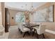 Traditional dining room with chandeliers, seating for eight, and a large decorative painting at 2101 Strada Mia Ct, Las Vegas, NV 89117