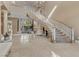 Stunning foyer with a grand staircase and elegant chandelier with natural light from large windows at 2101 Strada Mia Ct, Las Vegas, NV 89117