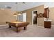Spacious game room features a billiard table, wet bar with wooden cabinets, and neutral carpet at 2101 Strada Mia Ct, Las Vegas, NV 89117