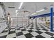 Spacious garage featuring a black and white checkered floor, car lift, and multiple garage doors at 2101 Strada Mia Ct, Las Vegas, NV 89117