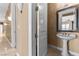 Hallway featuring a decorative mirror, pedestal sink, and views through the home's floor plan at 2101 Strada Mia Ct, Las Vegas, NV 89117