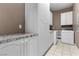 Laundry room with granite countertops, white cabinetry and a washer and dryer at 2101 Strada Mia Ct, Las Vegas, NV 89117