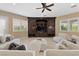 Cozy living room showcasing a ceiling fan, a wall of built-in cabinets, and comfortable seating at 2101 Strada Mia Ct, Las Vegas, NV 89117