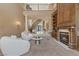 Elegant living room with a cozy fireplace, high ceilings, and a staircase to the upper level at 2101 Strada Mia Ct, Las Vegas, NV 89117