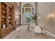 Bright living room with a fireplace, built-in shelving, and large windows overlooking the yard at 2101 Strada Mia Ct, Las Vegas, NV 89117