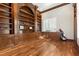 Home office with custom built-in bookshelves, hardwood flooring, and natural light at 2101 Strada Mia Ct, Las Vegas, NV 89117