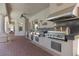 Covered outdoor kitchen features stainless steel appliances and bar top counter with BBQ at 2101 Strada Mia Ct, Las Vegas, NV 89117
