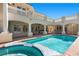 Inviting pool and spa with a covered outdoor kitchen, bar, and a spiral staircase to the upper level at 2101 Strada Mia Ct, Las Vegas, NV 89117