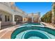 Lovely pool and spa with a covered outdoor kitchen, bar, and a spiral staircase to the upper level at 2101 Strada Mia Ct, Las Vegas, NV 89117