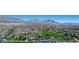 Expansive aerial view of community and surrounding mountains with clear blue sky at 2613 Country Mile Dr, Las Vegas, NV 89135