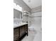 Bathroom with a dark vanity and white sink, alongside a tub shower with tiled walls at 2613 Country Mile Dr, Las Vegas, NV 89135