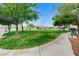 Community park featuring lush green grass, mature shade trees, sidewalks, and benches at 2613 Country Mile Dr, Las Vegas, NV 89135