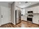 Modern kitchen featuring stainless steel appliances, white cabinets, and hardwood floors at 2613 Country Mile Dr, Las Vegas, NV 89135