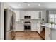 Well-lit kitchen with stainless steel appliances, white cabinets, and granite countertops at 2613 Country Mile Dr, Las Vegas, NV 89135
