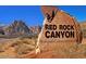 Sign for Red Rock Canyon National Conservation Area with mountains in the background at 2613 Country Mile Dr, Las Vegas, NV 89135